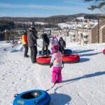 Visitors go snow tubing at Ascutney Outdoors in Brownsville, Vt., in January 2022.