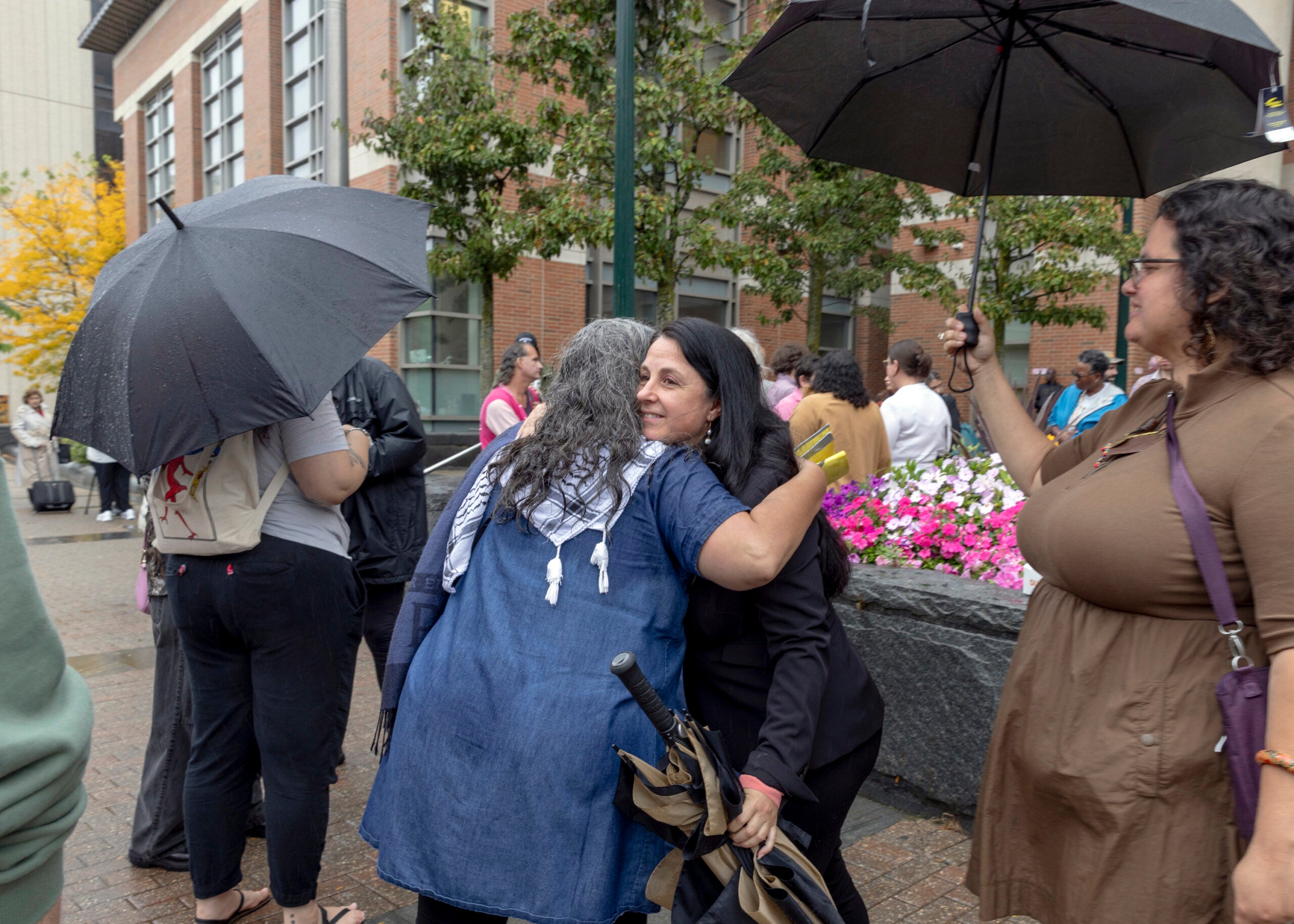 Etel Haxhiaj, a member of the City Council, is embraced after a court hearing in her criminal case in Worcester, Mass.