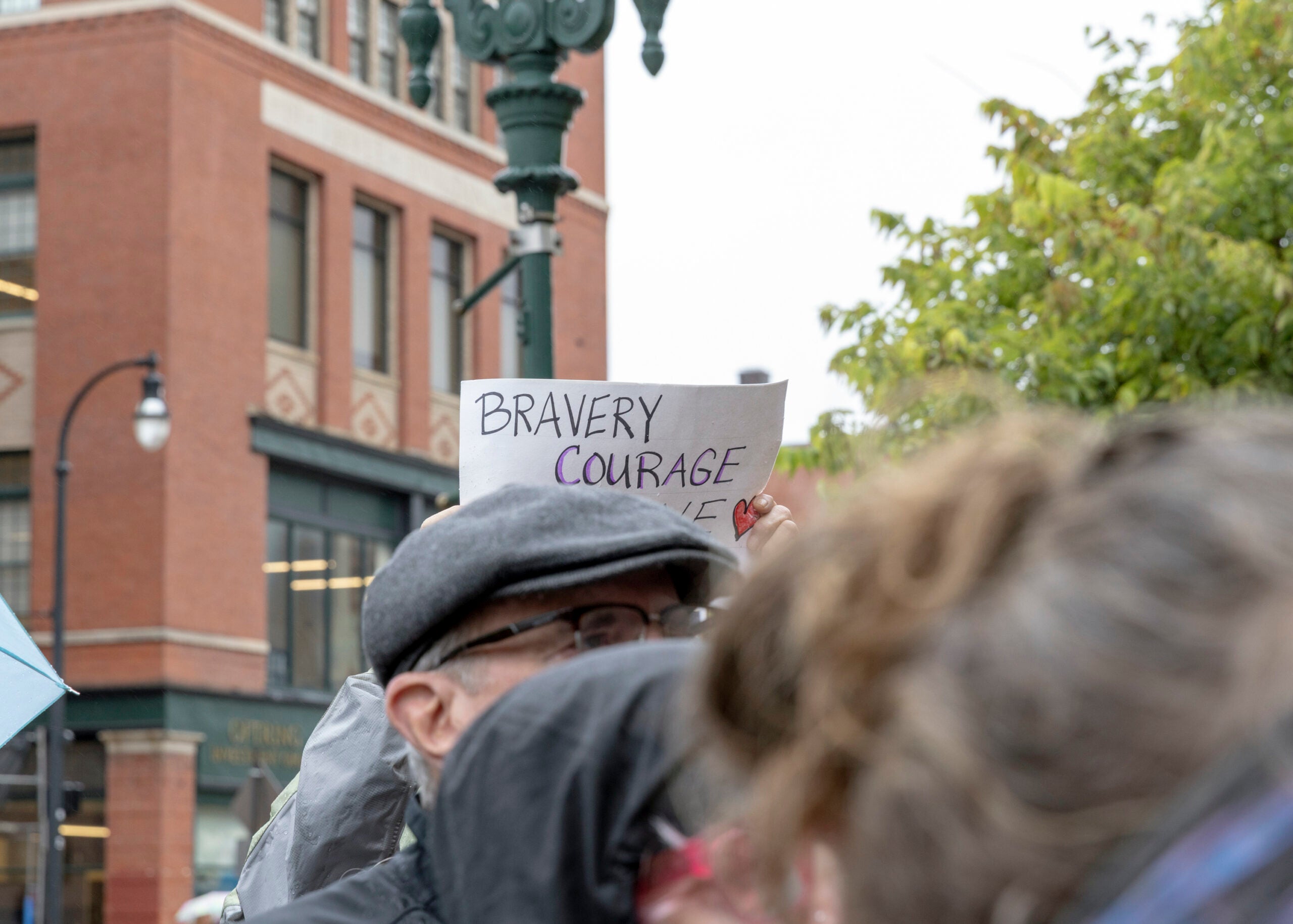 A supporter holds a sign as Etel Haxhiaj, a member of the City Council, speaks after a court hearing in her criminal case in Worcester, Mass.