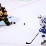 Boston Bruins right wing David Pastrnak (88) makes a save on a shot by Tampa Bay Lightning left wing Brandon Hagel (38), while protecting the empty net, during the third period of an NHL hockey game, Monday, Oct. 13, 2025, in Boston.