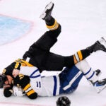 Boston Bruins defenseman Nikita Zadorov, top, drops Toronto Maple Leafs center Max Domi (11) to the ice during the third period of an NHL hockey game, Tuesday, Nov. 11, 2025, in Boston.