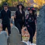 Costumed revelers walk through a graveyard in Salem.